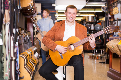 Boy and father choosing acoustic guitar