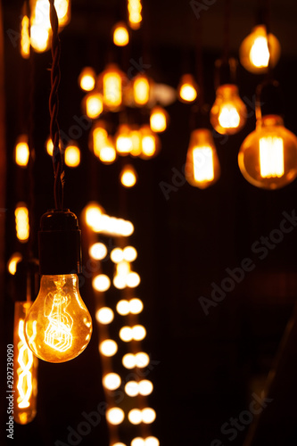 classic different retro light bulbs hanging on brick wall background at night