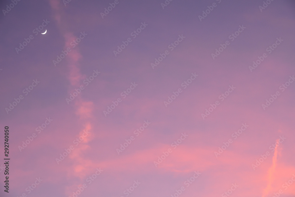 waning moon in a pink sky with beautiful clouds