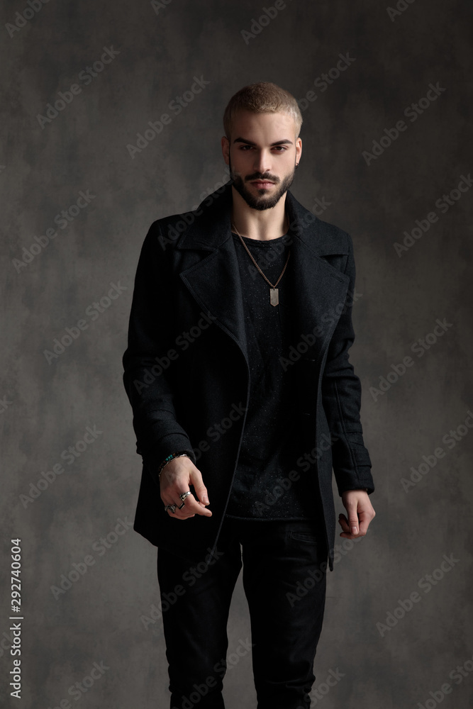 handsome fashion man wearing black longcoat in studio handsome fashion man wearing black longcoat in studio