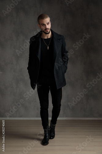 attractive young fashion man wearing black longcoat photo