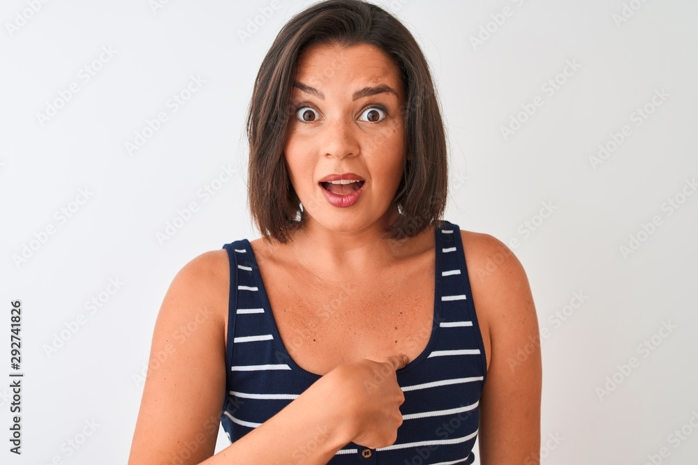 Young beautiful woman wearing blue striped t-shirt standing over isolated white background with surprise face pointing finger to himself Young beautiful woman wearing blue striped t-shirt standing over isolated white background with surprise face pointing finger to himself