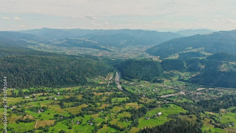 Aerial View on mountain village with forests, fields. Carpathian Mountains. Travel Vacation Nature Concept. Look down view background. 4K Footage. Aerial View on mountain village with forests, fields. Carpathian Mountains. Travel Vacation Nature Concept. Look down view background. 4K Footage.