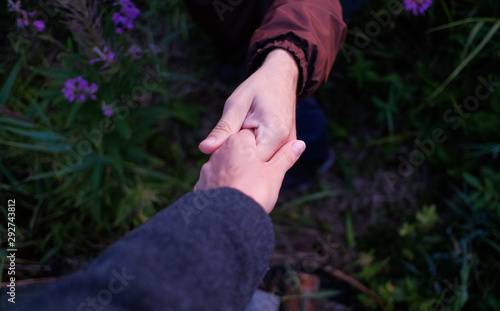 Close-up. Giving a helping hand. A man helps a woman pass obstacles. He gave her his hand for this.