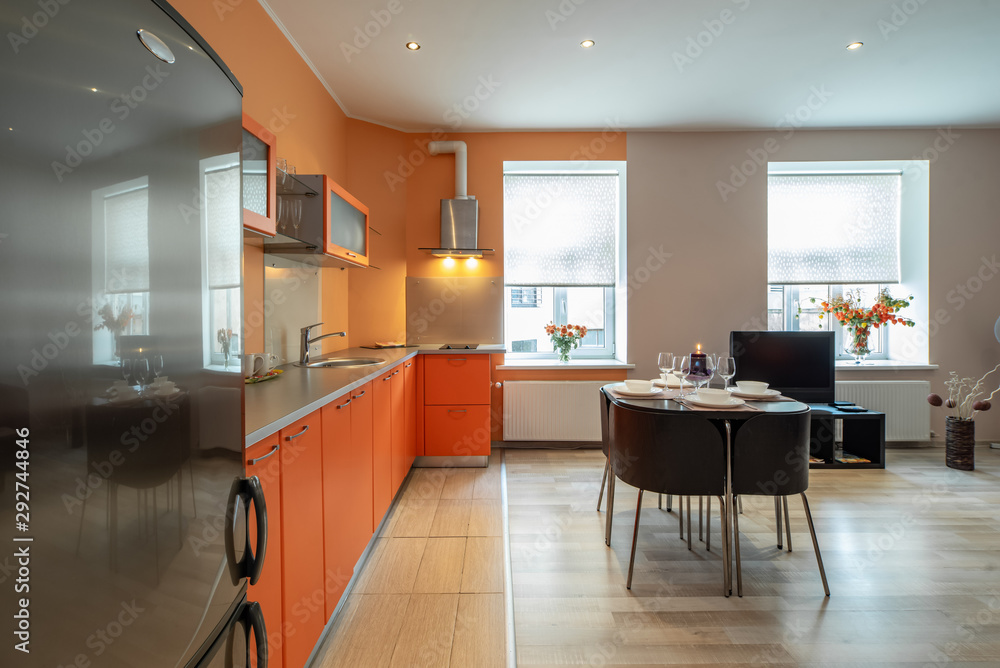 Fototapeta premium Modern interior of spacious light studio apartment. Kitchen set.