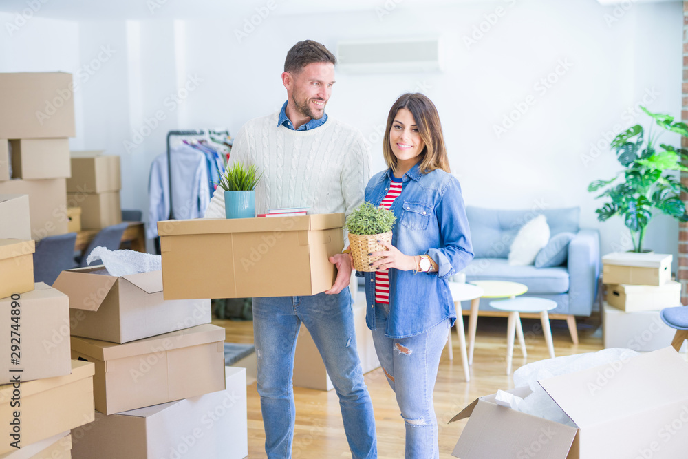Young beautiful couple moving cardboard boxes at new home Young beautiful couple moving cardboard boxes at new home