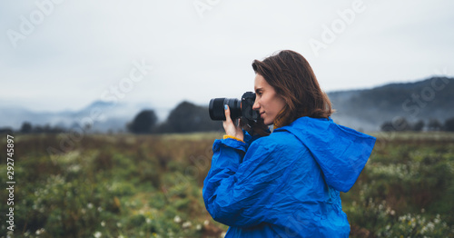 photographer tourist girl in blue raincoat hold in female hands photo camera take photography foggy mountain, traveler shoot autumn nature, click on camera technology, journey landscape vacation