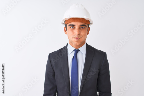 Young handsome architect man wearing suit and helmet over isolated white background puffing cheeks with funny face. Mouth inflated with air, crazy expression. © Krakenimages.com