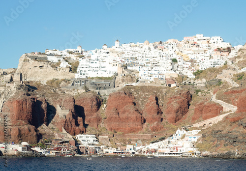 Greece, the island of Santorini.  A view of the beautiful town of Oia, clinging improbably to the cliff tops.  A sheer volcanic formaion, with whitewashed buildings. photo