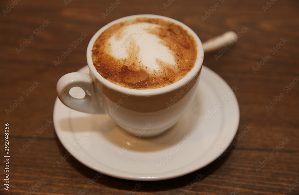 cup of cappuccino coffee on a brown wooden table. Morning drink breakfast. cup of cappuccino coffee on a brown wooden table. Morning drink breakfast.