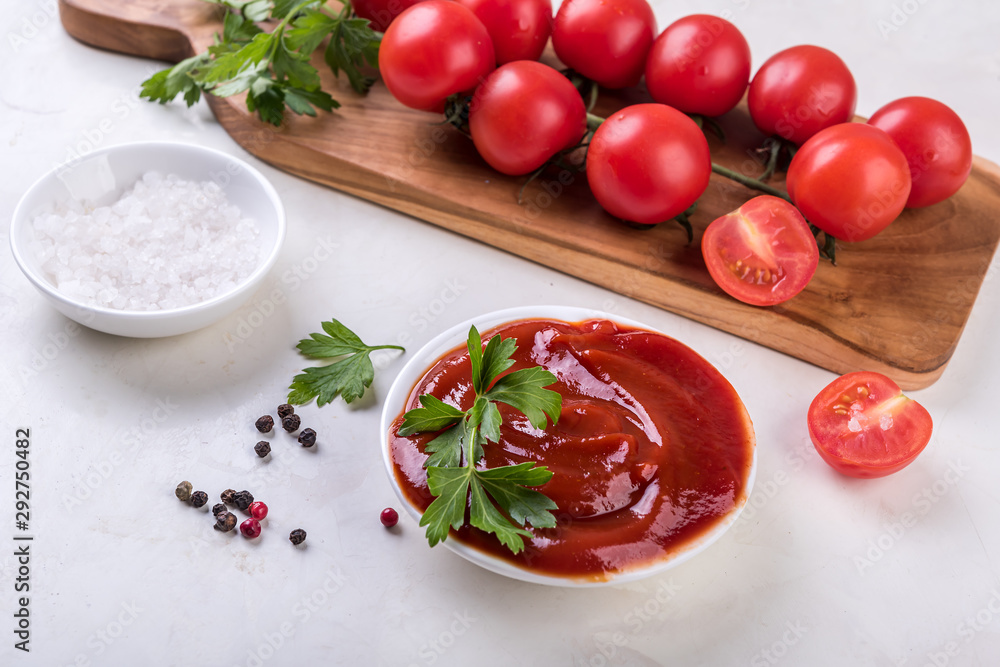 tomato sauce and fresh tomatoes on wooden board