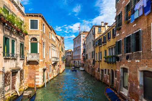 Scenic canal with ancient buildings and boats in Venice. 