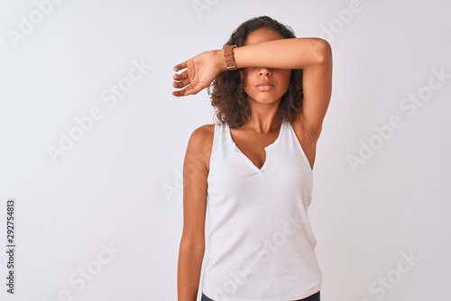 Young brazilian woman wearing casual t-shirt standing over isolated white background covering eyes with arm, looking serious and sad. Sightless, hiding and rejection concept