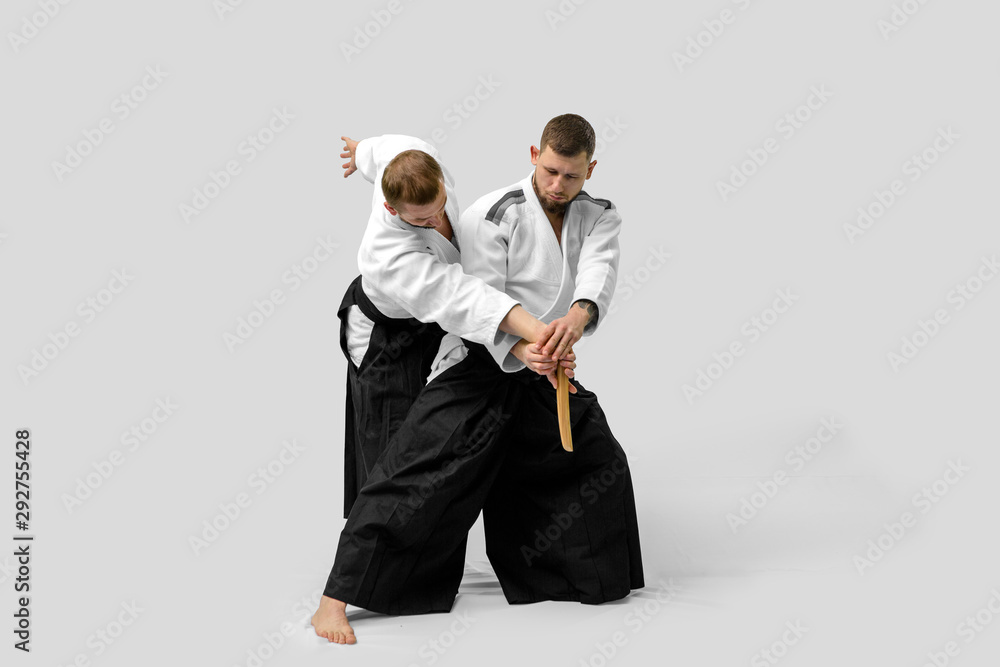 Two caucasian men are practicing aikido with waakizashi (isolation path included) Two caucasian men are practicing aikido with waakizashi (isolation path included)