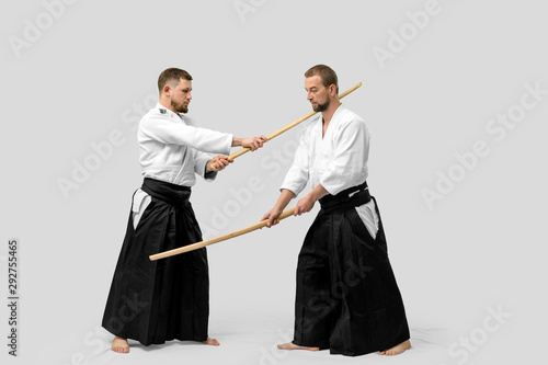 Two caucasian men are practicing aikido with Bokken (isolation path included)