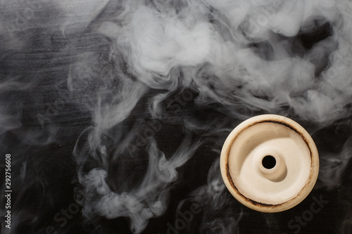  clay bowl for tobacco on a black background with smoke around