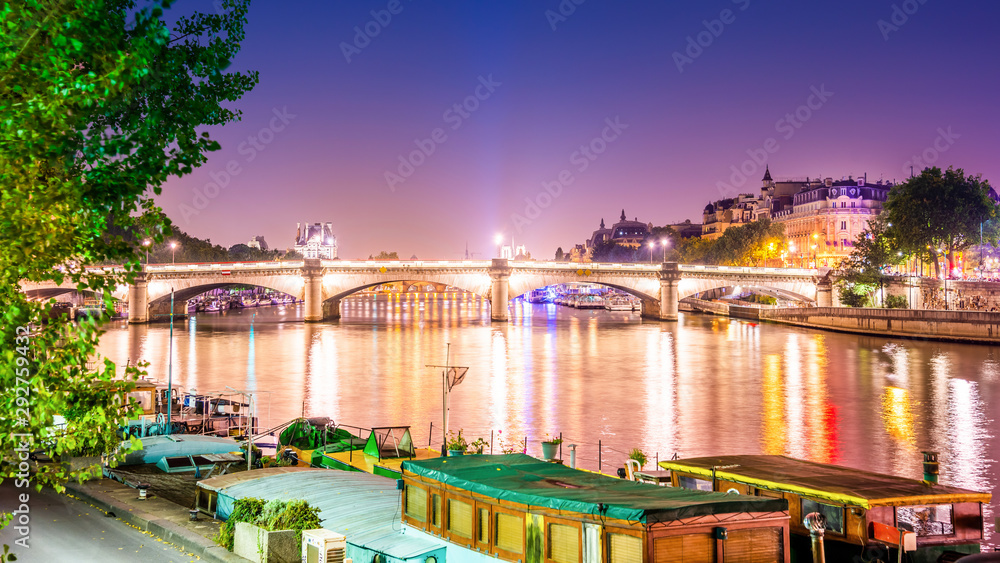 Die Seine in Paris bei Nacht mit einer alten beleuchteten Brücke