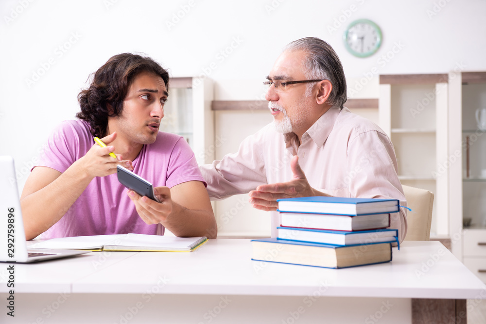 Old father helping his son in exam preparation Old father helping his son in exam preparation