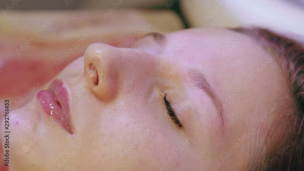 Beautician corrects the eyebrows of the client with tweezers and a brush. Beautician corrects the eyebrows of the client with tweezers and a brush.