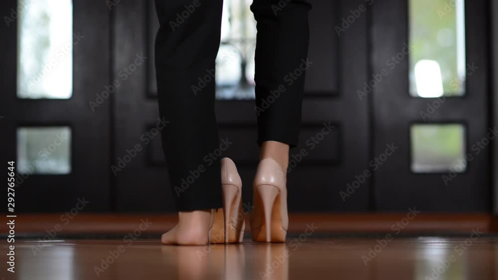 The girl puts on her shoes and leaves the house. Close-up of legs without face The girl puts on her shoes and leaves the house. Close-up of legs without face
