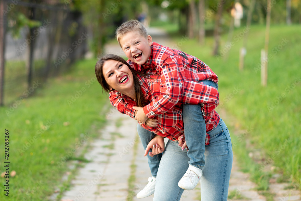 Mom, laughing, holds on his back a laughing son. Mom, laughing, holds on his back a laughing son.