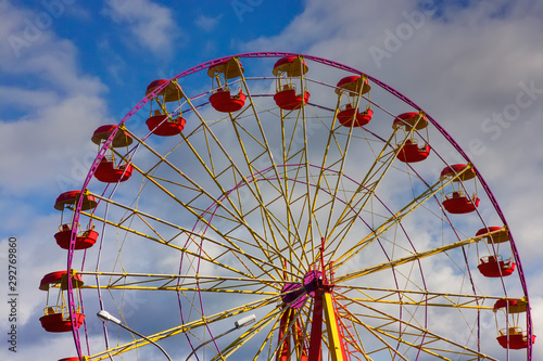 The Ferris wheel against the blue sky and clouds. Ferris wheel in the autumn park.