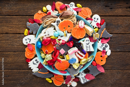 Halloween Jack o Lantern candy bowl with candy and halloween cookies Trick or Treat on old wooden background