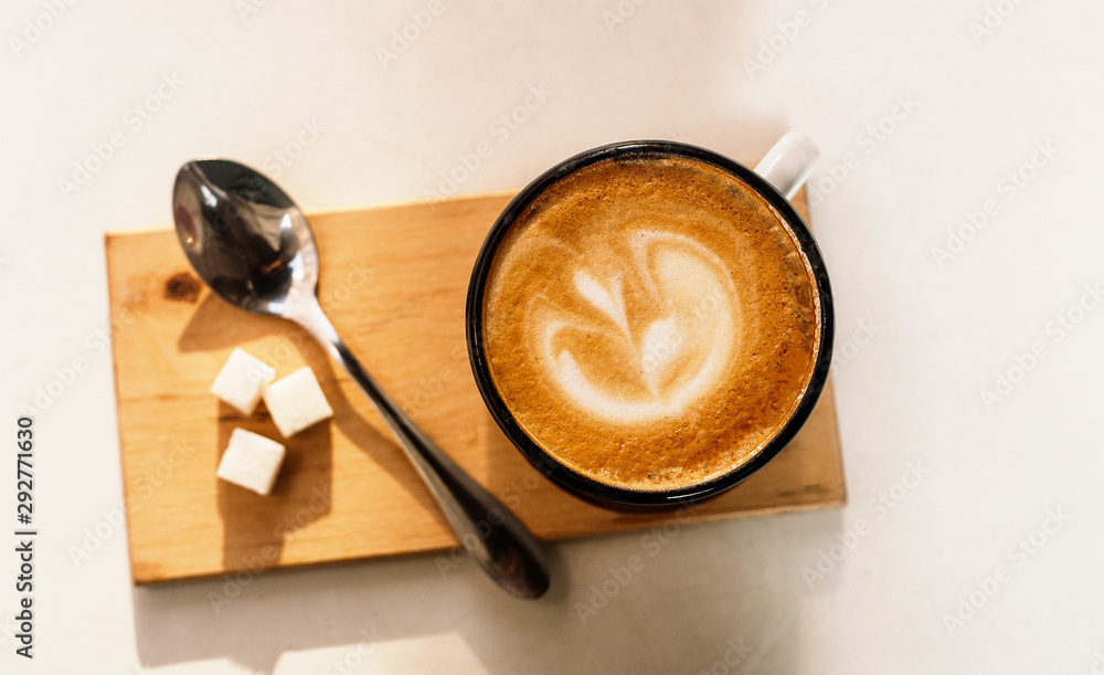 Cup of latte coffee with foam from above, spoon and sugar on white background. Cup of latte coffee with foam from above, spoon and sugar on white background.
