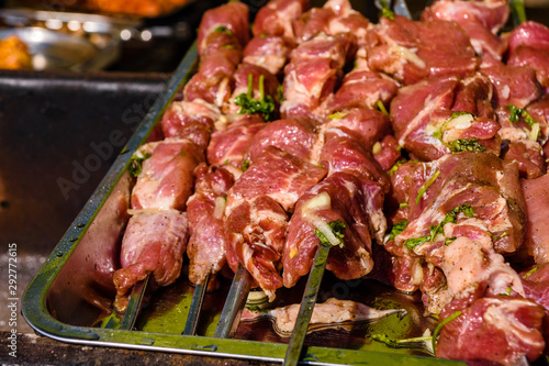 Skewers with raw meat over the charcoals. Cooking shashlik