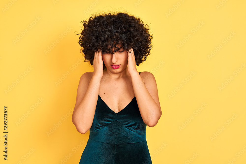 Young arab woman with curly hair wearing elegant dress over isolated yellow background with hand on head for pain in head because stress. Suffering migraine. Young arab woman with curly hair wearing elegant dress over isolated yellow background with hand on head for pain in head because stress. Suffering migraine.
