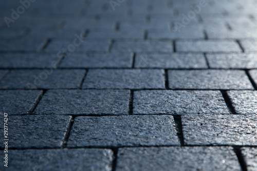 Dark grey granite rectangular pavement close-up texture background