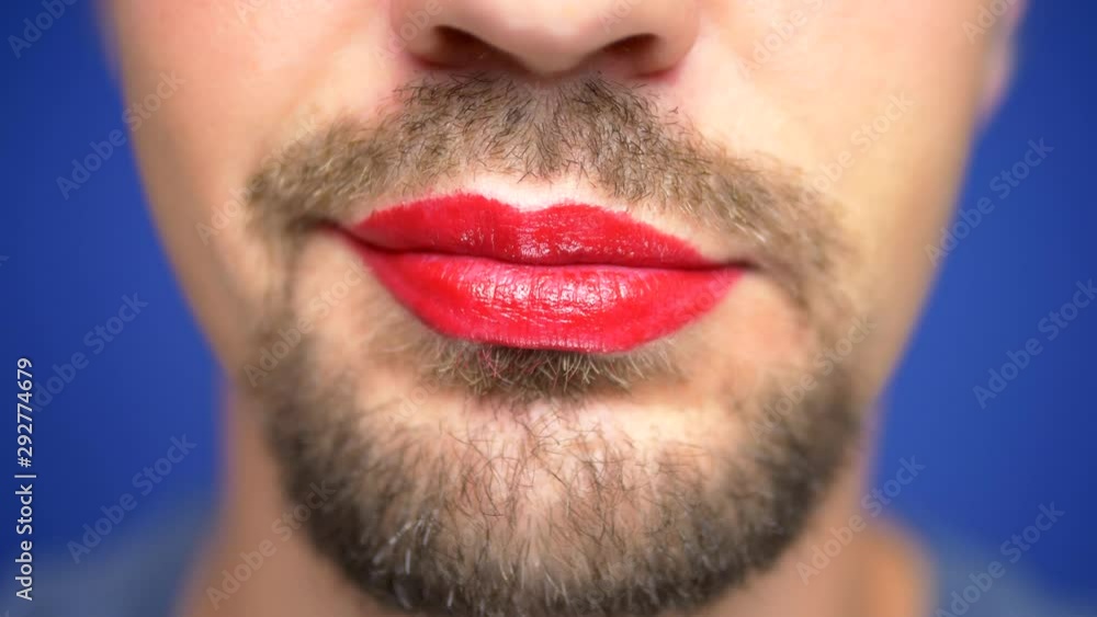 close-up. A bearded man with painted lips licks them sexually. close-up. A bearded man with painted lips licks them sexually.