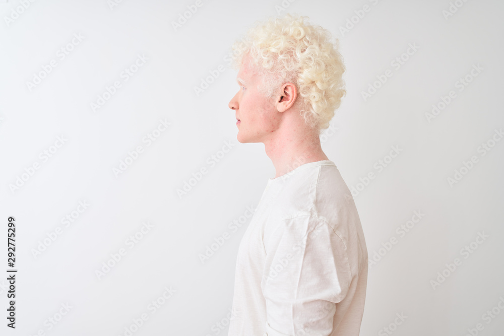 Young albino blond man wearing casual t-shirt standing over isolated white background looking to side, relax profile pose with natural face with confident smile. Young albino blond man wearing casual t-shirt standing over isolated white background looking to side, relax profile pose with natural face with confident smile.