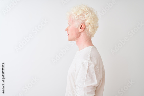 Young albino blond man wearing casual t-shirt standing over isolated white background looking to side, relax profile pose with natural face with confident smile.