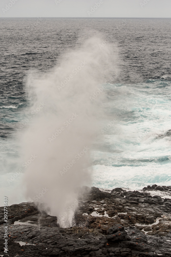 Ocean waves crash on the cliffs of Espanola Island in Galapagos for spectacular vaporized water geysers