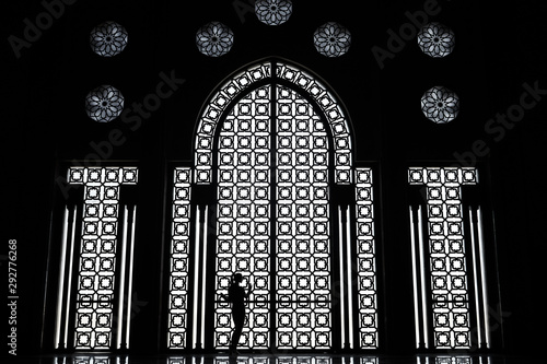 Black and white female silhouette, window with ornaments, Hassan II mosque in Casablanca, Morocco.    