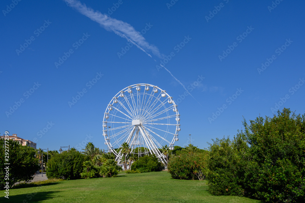 Big white Ferris wheel in Olbia Sardinia Park against blue sky Big white Ferris wheel in Olbia Sardinia Park against blue sky