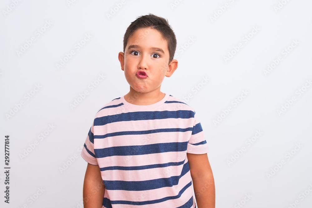 Beautiful kid boy wearing casual striped t-shirt standing over isolated white background making fish face with lips, crazy and comical gesture. Funny expression. Beautiful kid boy wearing casual striped t-shirt standing over isolated white background making fish face with lips, crazy and comical gesture. Funny expression.