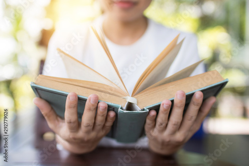 holding book opened in two hands on table, wisdom and knowledge concept