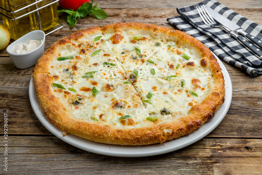 Pizza Quattro formaggi on wooden table Pizza Quattro formaggi on wooden table