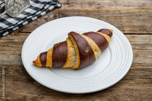 Croissant with chocolate on wooden table