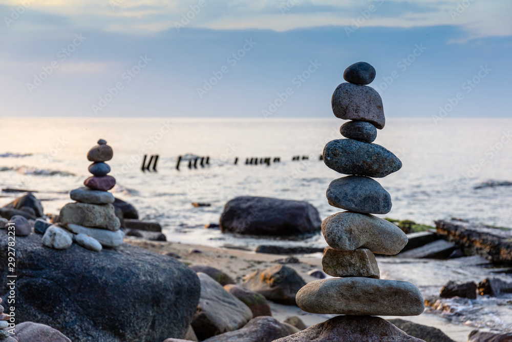 pyramid of small smooth stones by the sea against the sunset sky pyramid of small smooth stones by the sea against the sunset sky