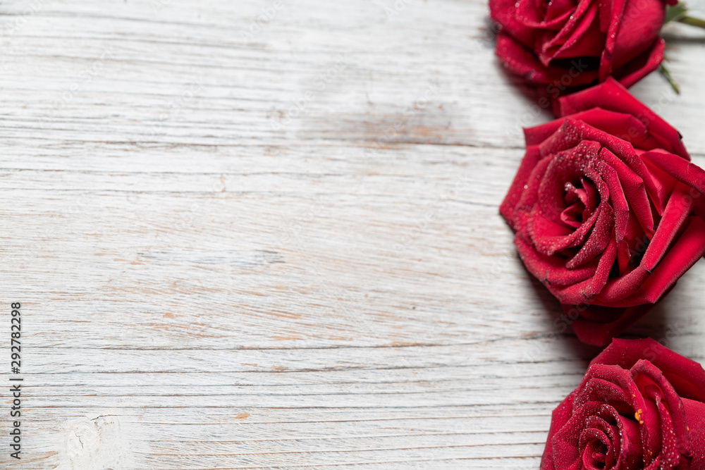 Three Red roses on light wooden background with copy space, top view  - Image