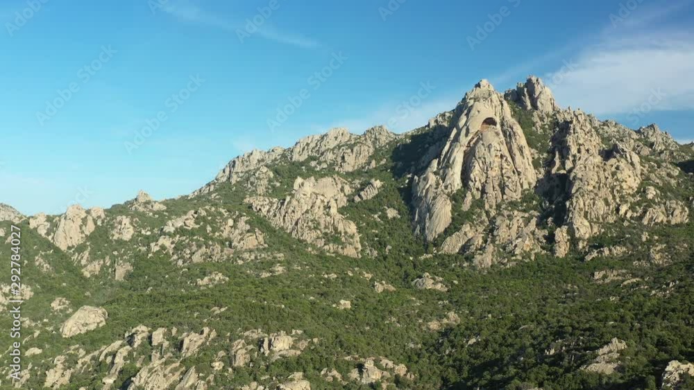View from above, aerial view of some stunning granite mountains surrounded by a rich and green vegetation in San Pantaleo, Sardinia, Italy. View from above, aerial view of some stunning granite mountains surrounded by a rich and green vegetation in San Pantaleo, Sardinia, Italy.