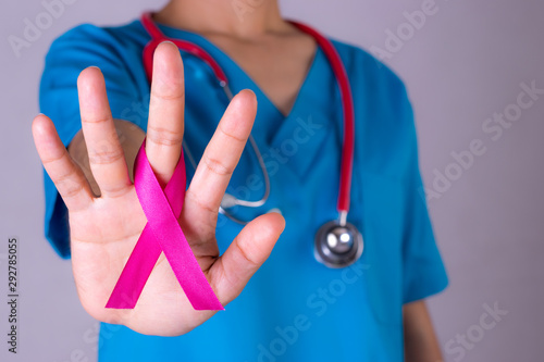 Doctor holding a pink ribbon. Breast cancer awareness month.
