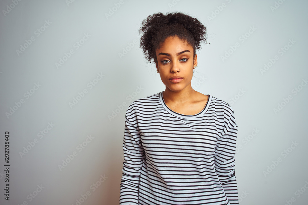 African american woman wearing navy striped t-shirt standing over isolated white background looking sleepy and tired, exhausted for fatigue and hangover, lazy eyes in the morning. - obrazy, fototapety, plakaty 
