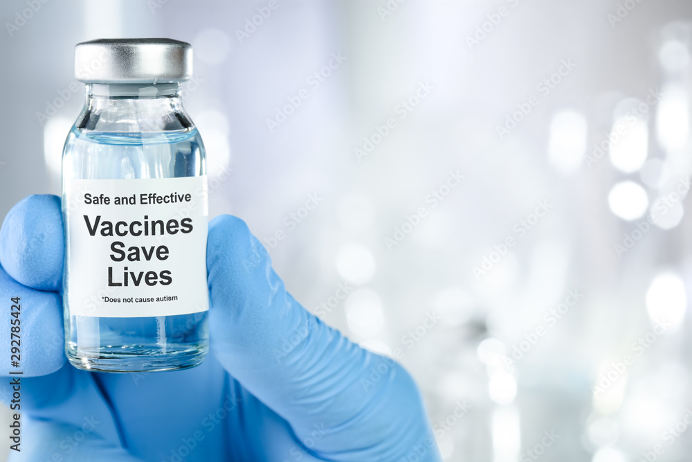 Healthcare concept with a hand in blue medical gloves holding a vaccine vial wtih the words Safe and Effective, Vaccines Save Lives, and does not cause autism Healthcare concept with a hand in blue medical gloves holding a vaccine vial wtih the words Safe and Effective, Vaccines Save Lives, and does not cause autism