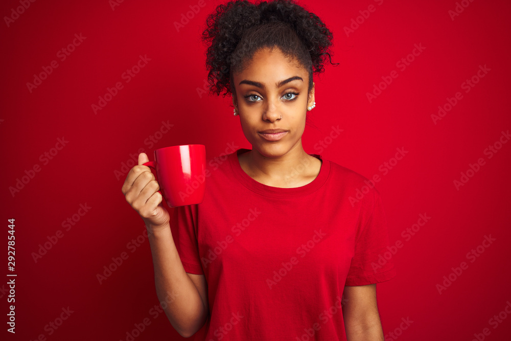 Young african american woman drinking a cup of coffee over isolated red background with a confident expression on smart face thinking serious Young african american woman drinking a cup of coffee over isolated red background with a confident expression on smart face thinking serious