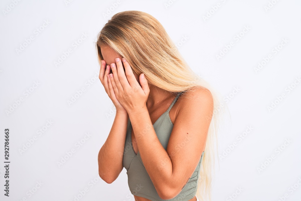 Young beautiful woman wearing casual green t-shirt standing over isolated white background with sad expression covering face with hands while crying. Depression concept. Young beautiful woman wearing casual green t-shirt standing over isolated white background with sad expression covering face with hands while crying. Depression concept.