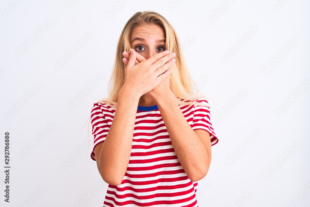 Young beautiful woman wearing red striped t-shirt standing over isolated white background shocked covering mouth with hands for mistake. Secret concept. Young beautiful woman wearing red striped t-shirt standing over isolated white background shocked covering mouth with hands for mistake. Secret concept.